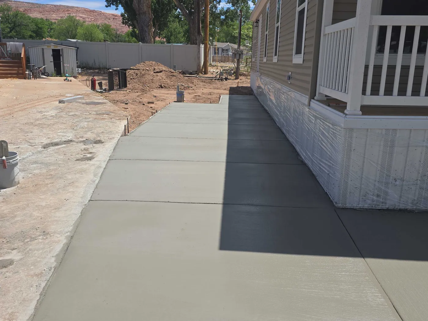 New concrete sidewalk and patio poured beside a covered porch